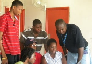 Web design students Xavier Inniss (standing at left), Jamal Als, Betty Jones, Damian Williams, Amanda Nelson (at the computer) and Patrick Yearwood.