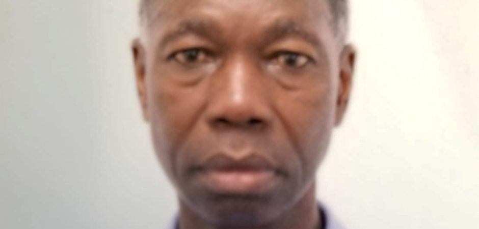 Basil Springer is about 5 feet 9 inches tall, dark complexion, black short hair which is slightly grey. He has a scar on his left ear, a long thin neck, drooping shoulders, long arms and is soft-spoken.