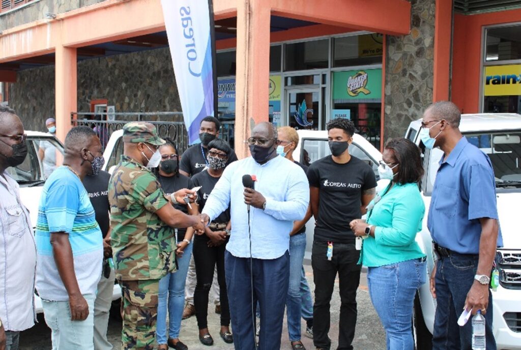 Joel Providence (centre) presents keys to Colin John - Commissioner of Police, in the presence of Hudson Nedd, Permanent Secretary, Ministry of National Security (right) and Michelle Forbes, NEMO Director (near right)