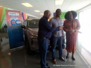 4-time winner of prestigious calypso contest Pic O'De Crop Ian Webster better known as i-Web, savors glorious moment of the Nissan E Power X-Trail's keys put in his hand from Samuel Gaston, Regional Product Manager of Courtesy Garage as CEO of the NCF, Ms Carol Roberts-Reifer watches in approval.