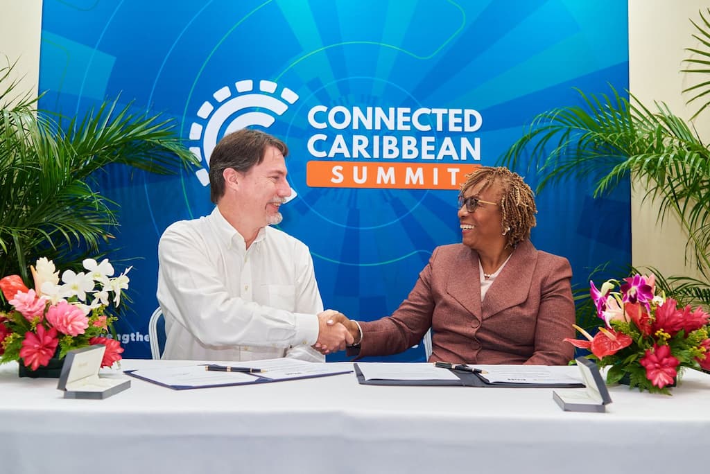 Bill Woodcock (left), Secretary-General of Packet Clearing House and Dr. Claire C. Craig, Director and Board Secretary of the Caribbean Network Operators Group, sign the memorandum of cooperation during the Connected Caribbean Summit, held at Radisson Grenada Beach Resort, Grande Anse, St. George’s, Grenada, on December 2, 2025. Photo courtesy: Caribbean Network Operators Group.