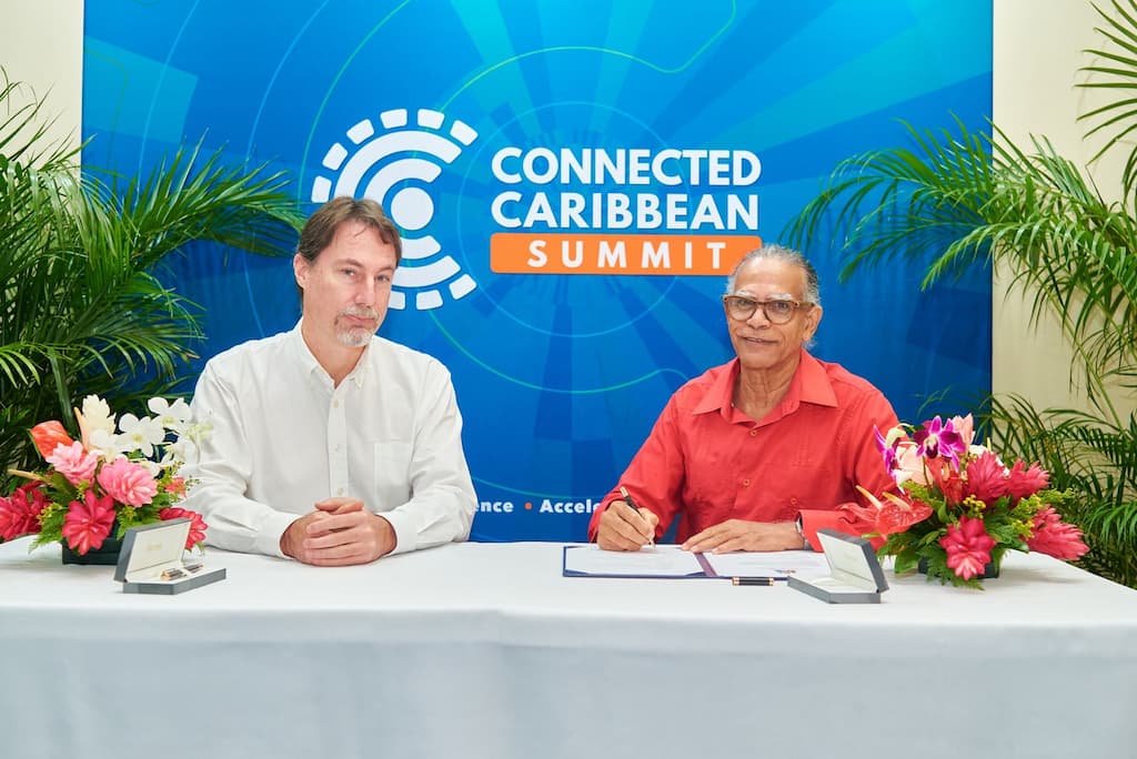 Bill Woodcock (left), Secretary-General of Packet Clearing House and Vincent Roberts, Chairman of the National Telecommunications Regulatory Commission of Grenada, sign the convention on December 2, during the Connected Caribbean Summit, held this week at Radisson Grenada Beach Resort, Grande Anse. Photo courtesy: Connected Caribbean.